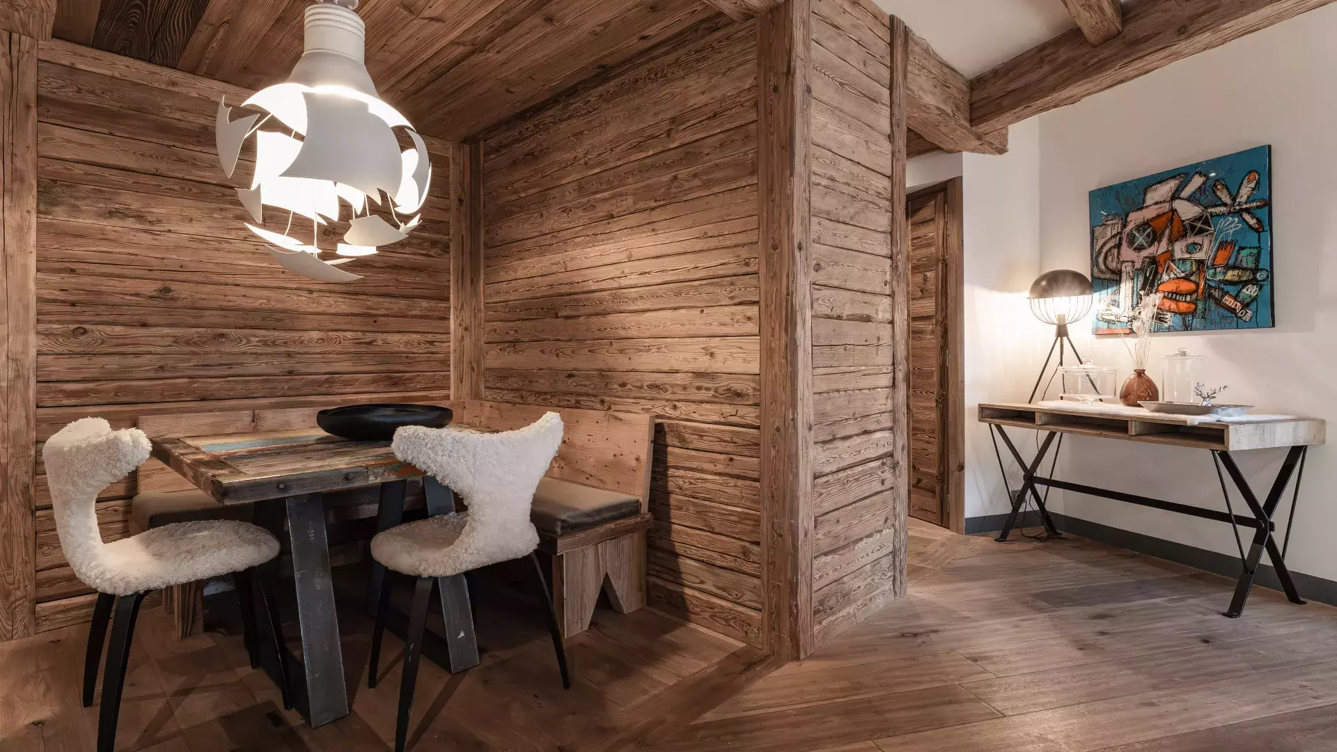 Coin détente intimiste avec table de jeu en bois, banc d'angle et chaises en fourrure